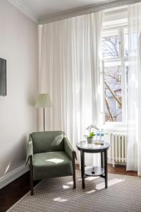 a living room with a green chair and a table at Apart Sova Dream apartments in Novi Sad