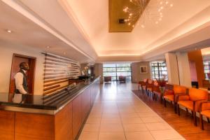 a lobby with a bar with orange chairs at City Lodge Hotel Sandton, Katherine Street in Johannesburg