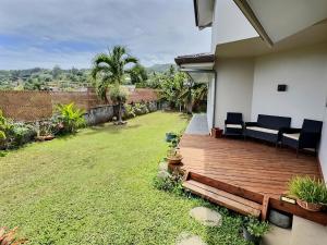 a house with a wooden deck in a yard at Te Vai Moana, Your Oasis Near Airport in Faaa