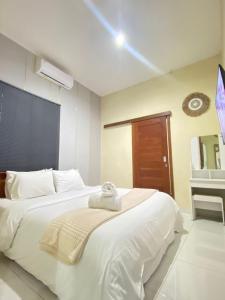 Un dormitorio con una cama blanca con una toalla encima. en 1BR The Shangka House Nusa Dua, en Nusa Dua