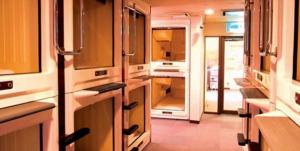 a kitchen with an open door in a train at Capsule Hotel & Sauna Ikebukuro Plaza in Tokyo