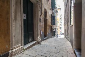 an empty alley with a person walking down the street at OStellin Genova Hostel in Genoa