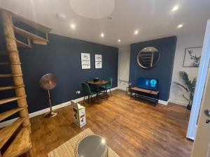 a living room with a table and a blue wall at First Avenue Apartments in Moffat