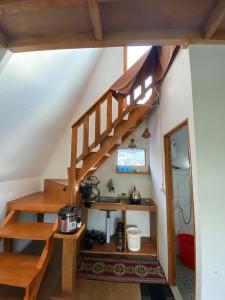 Village Garden Homestay 2 في Diyeng: درج خشبي في منزل مع غرفه