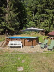 a pool table with an umbrella and two chairs at LA PARENTHÈSE AU PAYS DU VERT in Soucht +29 photos