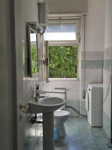 a bathroom with a sink and a toilet and a window at Room PR Casa Solari in Genova
