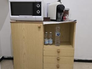 a microwave and water bottles on a wooden cabinet at Room PR Casa Solari in Genova +10 photos