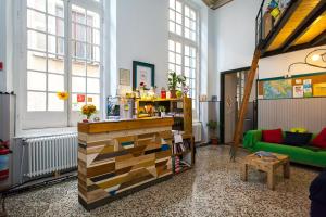 a room with a book shelf and a green couch at OStellin Genova Hostel in Genoa