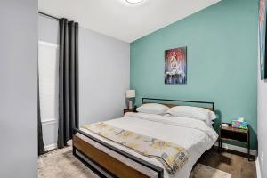 a bedroom with a bed with a blue wall at Close to everything downtown in Indianapolis