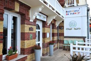 a facade of a restaurant with chairs on a porch at Hotel Le Rayon Vert in Étretat