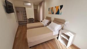 a small room with two beds and a television at Casa al Duomo in Nicosia