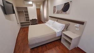 a small bedroom with a bed and a tv at Casa al Duomo in Nicosia