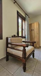 a wooden bench in a room with a window at Villa Dimitra in Agios Dimitrios