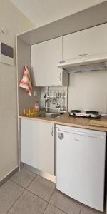 a kitchen with white cabinets and a sink at Villa Dimitra in Agios Dimitrios