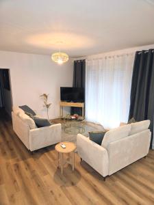 a living room with two couches and a table at Escale 1 Spacieux avec CLIM in Tartas +5 photos