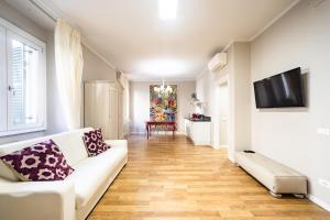 Una sala de estar con un sofá blanco y un televisor de pantalla plana. en Suite Santa Eufemia 2 - VICINO ARENA, en Verona
