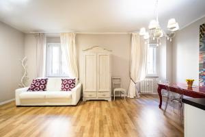 Una sala de estar con un sofá blanco y una mesa. en Suite Santa Eufemia 2 - VICINO ARENA, en Verona