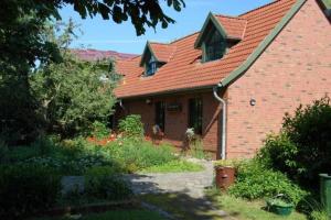 a brick house with a red roof at Ferienwohnungen Meyer in Bollewick