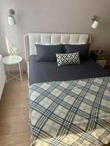 a bed with a blue and white blanket and a chair at Seebloom in Perea