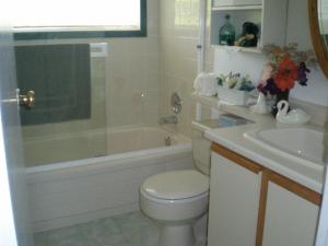 een badkamer met een bad, een toilet en een wastafel bij Island View B&B in Nanaimo