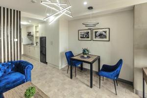 a living room with a table and blue chairs at La Grande Residence unit 2-909 in Angeles