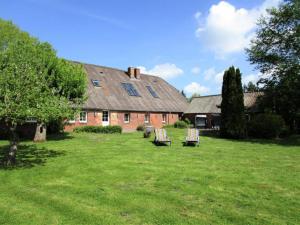 a house with two lawn chairs in the yard at Ferienwohnung Galerie 2 in Niedersachsen-Stadland +16 photos