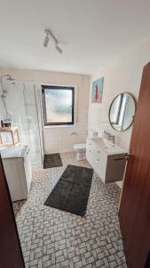 a bathroom with a sink and a toilet and a mirror at Ruhige Wohnung mit Ausblick in Extertal +13 photos