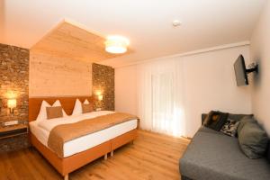 pokój hotelowy z łóżkiem i kanapą w obiekcie Luxusapartment Müllerhaus w mieście Mühlbach am Hochkönig +37 zdjęć