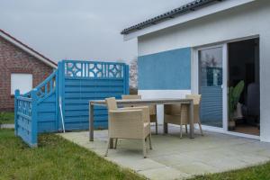 a patio with a table and chairs in a yard at Ferienhaus Möwennest in Sehestedt