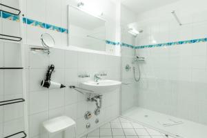 ein weißes Badezimmer mit Waschbecken und Dusche in der Unterkunft Villa Aegir Villa Aegir 002 in Heringsdorf
