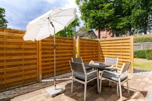 ein Tisch und Stühle mit einem Sonnenschirm auf einer Terrasse in der Unterkunft Villa Aegir Villa Aegir 002 in Heringsdorf