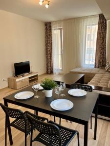 sala de estar con mesa negra y sillas en Apartments Flora 1, en Burgas