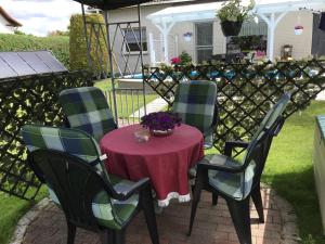 a table with four chairs and a table with flowers on it at Ferienwohnung an der Müritz 1 Groß in Bollewick