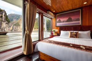 Un dormitorio con una cama y una ventana grande. en Cozy Bay Cruise, en Ha Long