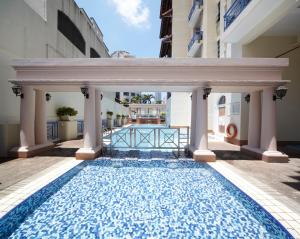 einem Pool in einem Gebäude mit Säulen und einem Pool in der Unterkunft Village Residence Robertson Quay by Far East Hospitality in Singapur