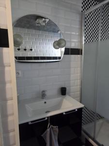 a bathroom with a white sink and a mirror at LA PARENTHÈSE AU PAYS DU VERT in Soucht