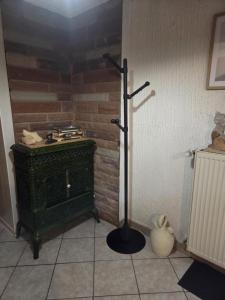 a room with a green stove in a corner at LA PARENTHÈSE AU PAYS DU VERT in Soucht