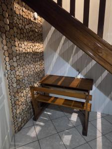 a wooden bench sitting under a stair case at LA PARENTHÈSE AU PAYS DU VERT in Soucht