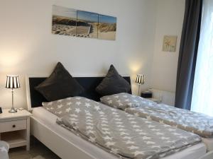 a bedroom with two beds and two lamps and a picture at Residenz Passat Cuxhaven 5 in Cuxhaven