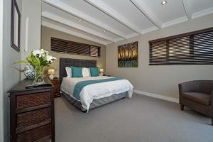 a bedroom with a bed and a chair at Atlantica in Yzerfontein +19 photos