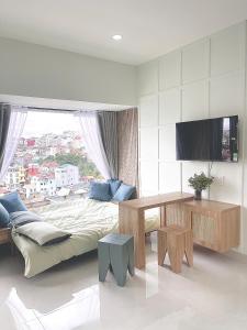 une chambre avec un lit, une table et une télévision dans l'établissement LENA Home, à Đà Lạt
