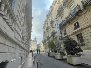 een lege straat in een stad met gebouwen bij Hotel de La Comédie in Montpellier