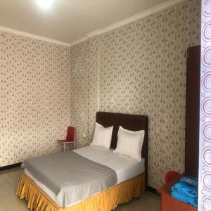 a bedroom with a bed in a room with wallpaper at Hotel O Madina Homestay in Samarinda