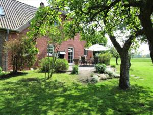 a brick house with a table and an umbrella at Ferienwohnung Komfort in Niedersachsen-Stadland
