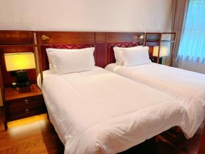 Postel nebo postele na pokoji v ubytování Jingshan Garden Hotel