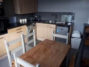 a kitchen with a wooden table and a sink at 2 bed flat Centre Swansea in Swansea
