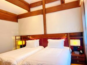 Postel nebo postele na pokoji v ubytování Jingshan Garden Hotel