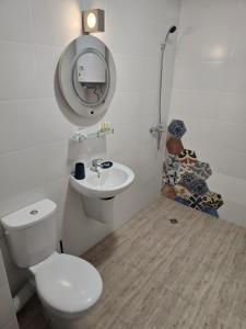 a bathroom with a toilet and a sink and a mirror at Апартамент "Paradise" Червенка in Chernomorets