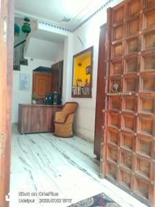 a room with a wooden door and a desk at Little Peepal House in Udaipur