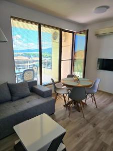 a living room with a couch and a table with chairs at Апартамент "Paradise" Червенка in Chernomorets +39 photos